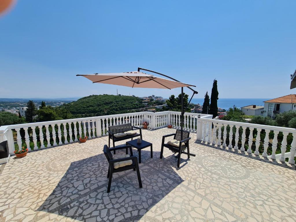een patio met 2 stoelen en een parasol bij Luxury Penthouse with panoramic view in Ulcinj