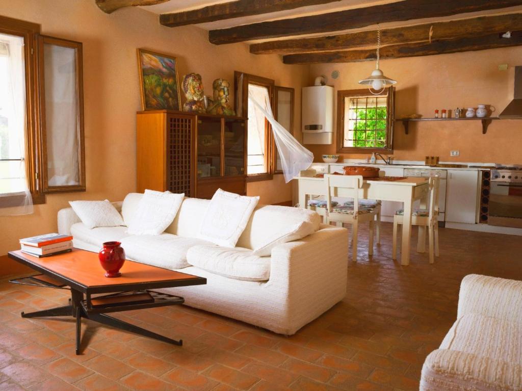 sala de estar con sofá blanco y mesa en La Casa di Laura, en Castelcucco