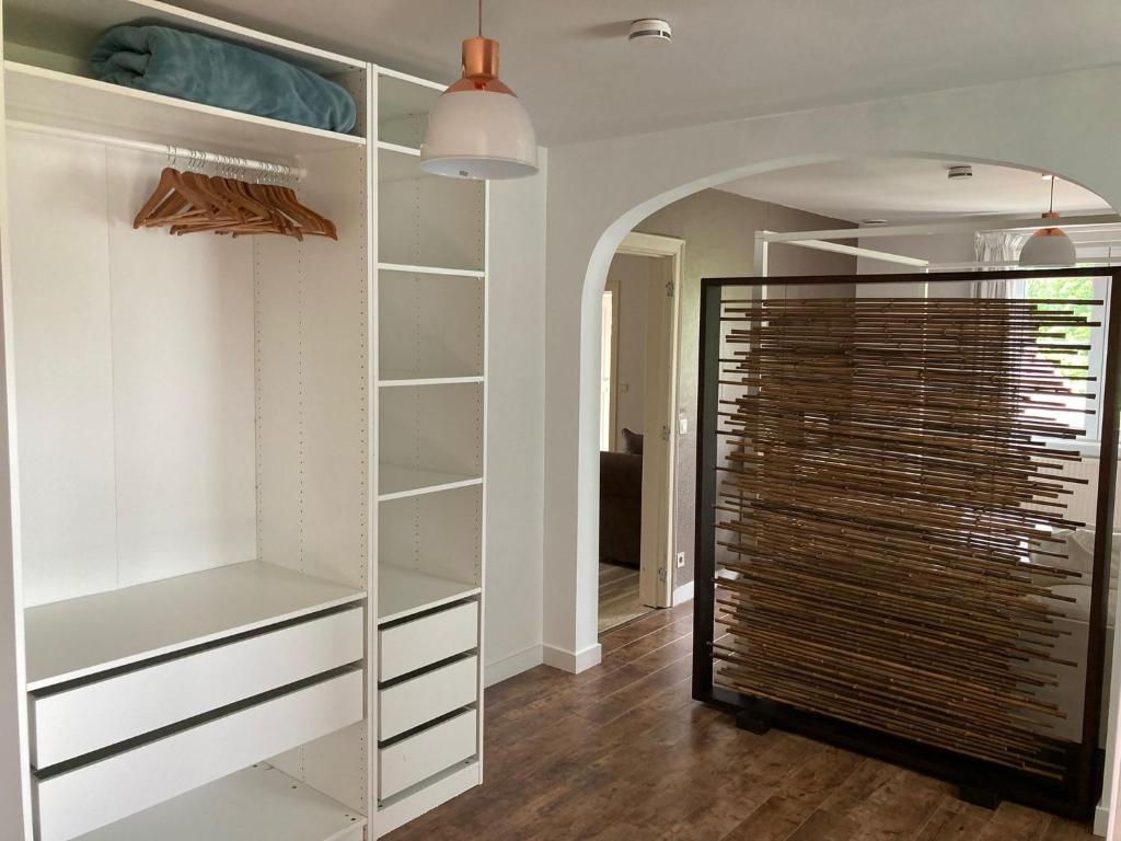 una cabina armadio con armadi bianchi e una porta in vetro di Rustig appartement in het groen met terras a Kontich