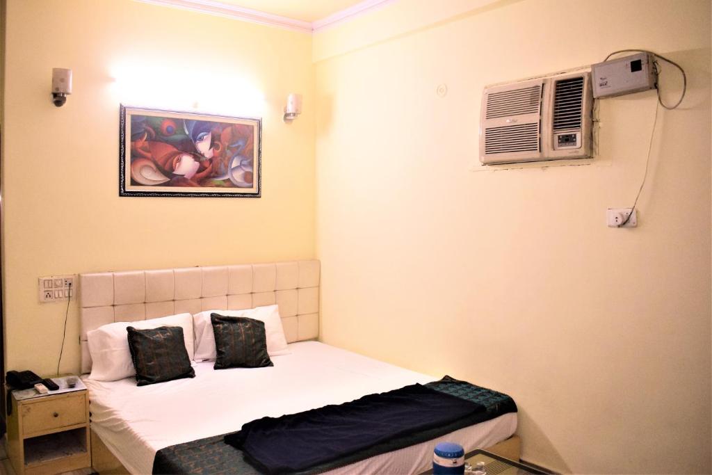 a bedroom with a bed and a air conditioner at DS Residency in Varanasi