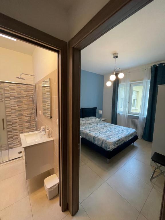 a bedroom with a bed and a bathroom at Lugaro Guest House in Turin