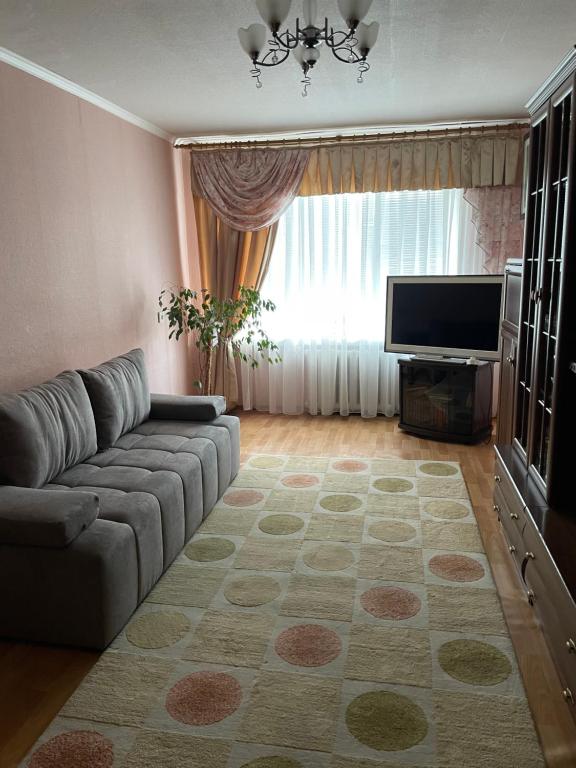 un soggiorno con divano e TV a schermo piatto di Здається квартира подобово a Kam"janec'-Podil's'kyj