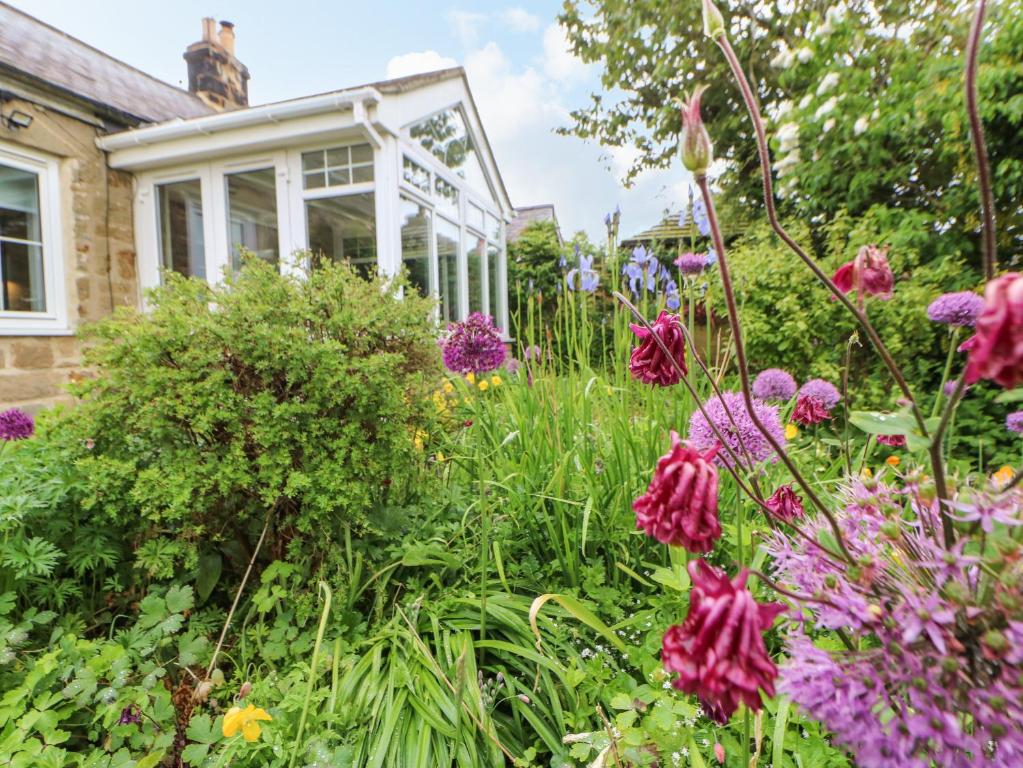 a garden with flowers in front of a house at The Cottage, 5 Richley Terrace in Newcastle upon Tyne