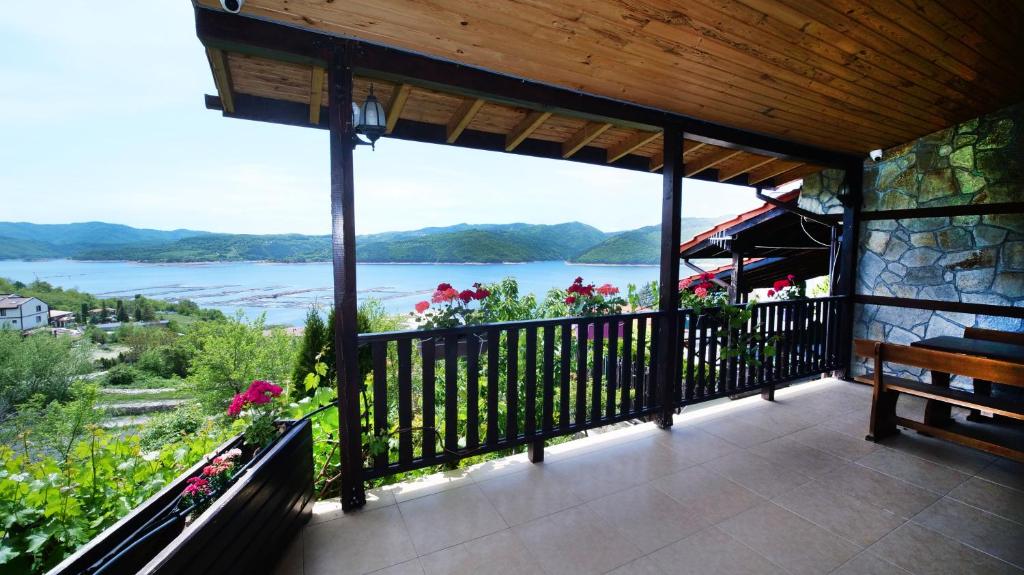 a balcony with a bench and a view of the water at Penev guest house in Glavatartsi