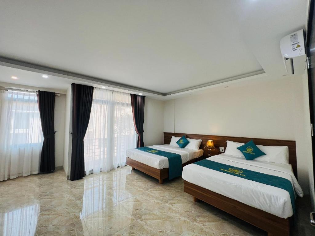 ein Hotelzimmer mit 2 Betten und Fenstern in der Unterkunft Sunrise Motel in Hạ Long