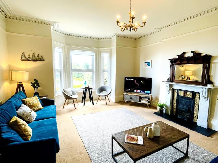 a living room with a blue couch and a fireplace at Lottie's Lookout, Ventnor with fantastic Sea Views in Ventnor