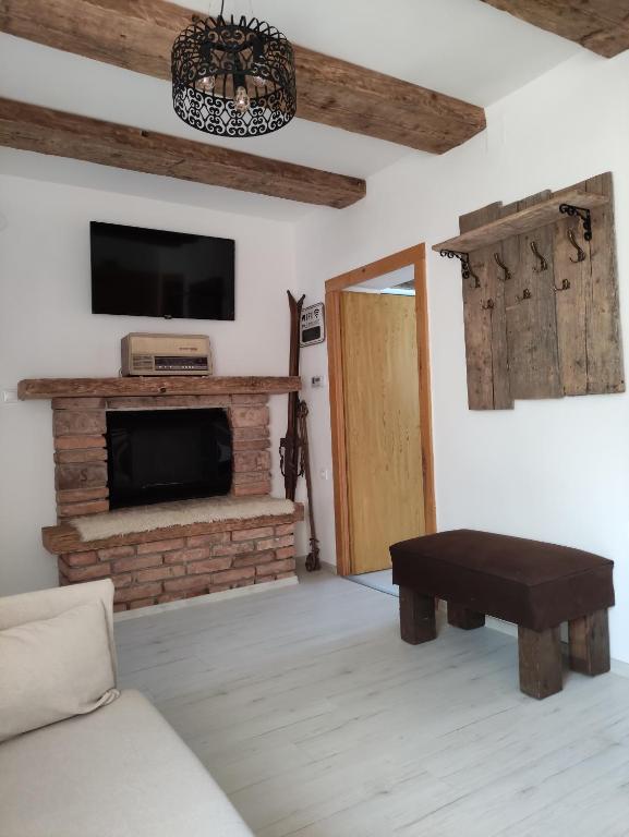 a living room with a couch and a tv and a fireplace at Patak28 Apartmanok in Sopron