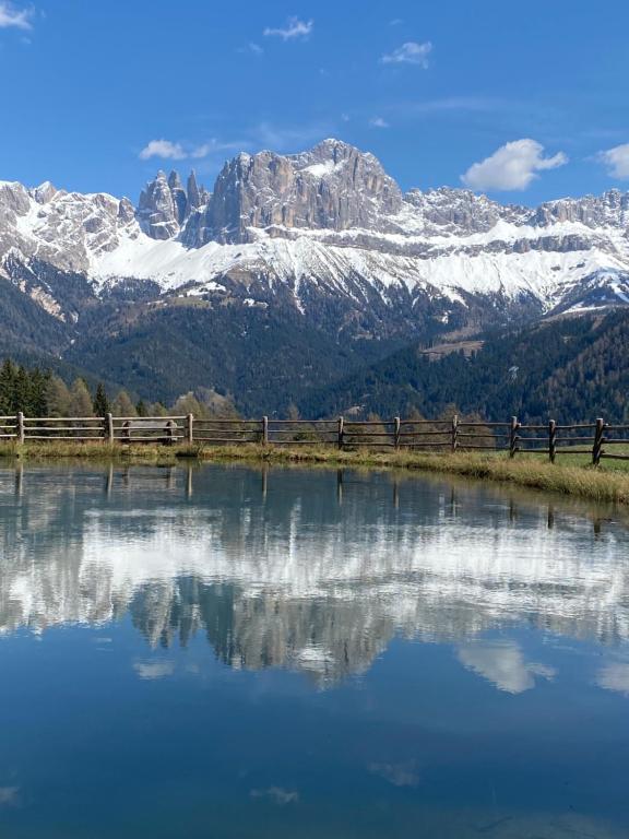 a reflection of a snow covered mountain in a lake at Schneiderhaus in Bagni di Lavina Bianca