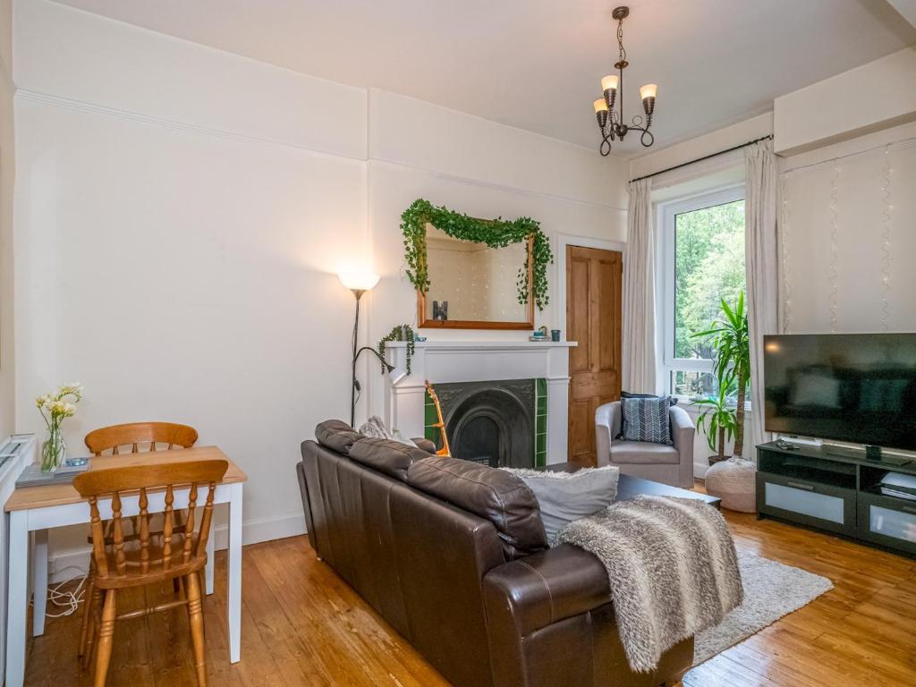 a living room with a couch and a fireplace at Pass the Keys Superb 1 Bed Flat in Traditional Victorian Building in Edinburgh