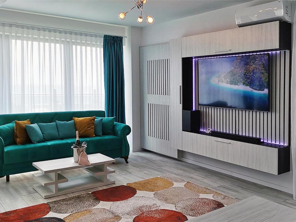 a living room with a green couch and a flat screen tv at Ada Luxury Apartments 57 in Mamaia