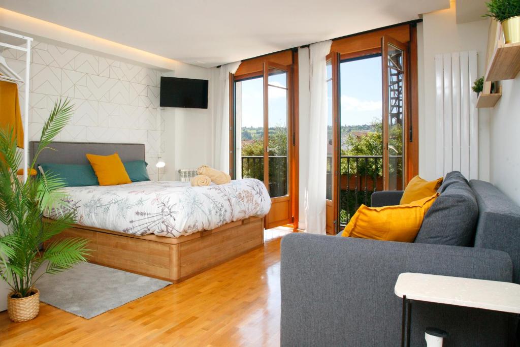 a living room with a bed and a couch at Loft " La fábrica de Gas",PARKING in Oviedo