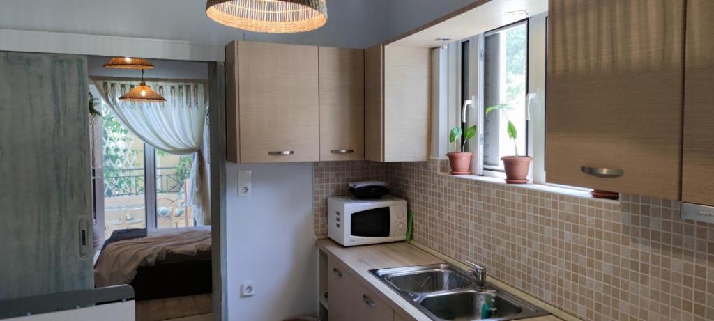 a kitchen with a sink and a microwave at KD Boho Home in Lávrion