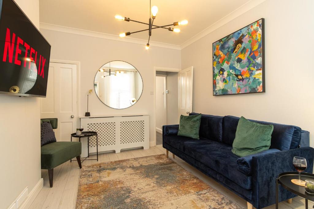 a living room with a blue couch and a mirror at Branston House in Burton upon Trent