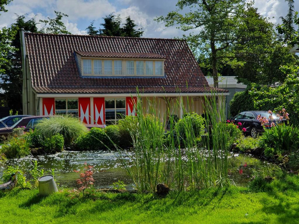 a house with a pond in front of it at Bed & breakfast FF rust in Kockengen