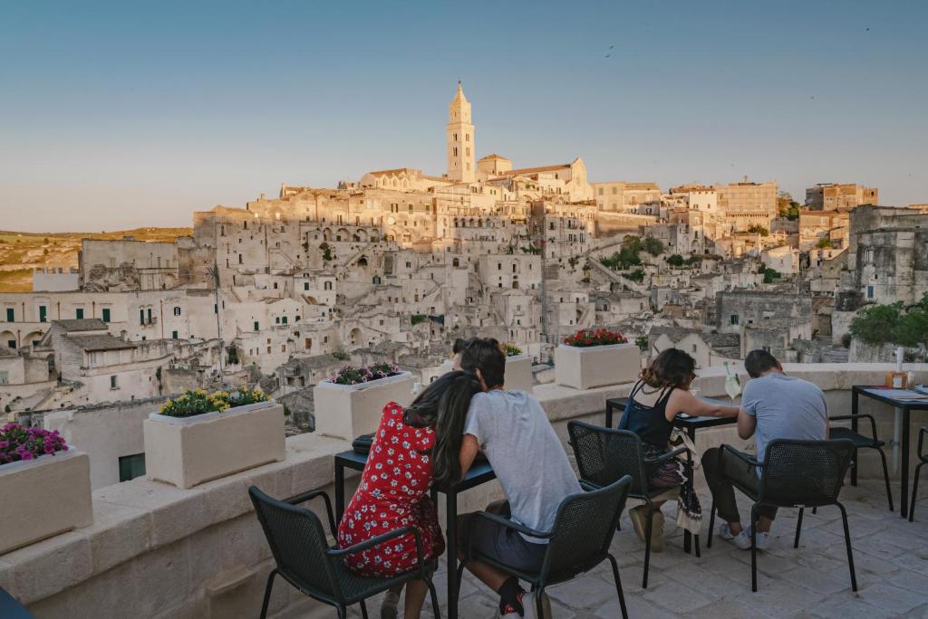 een groep mensen die in stoelen naar een stad zitten te kijken bij Palazzo Degli Abati in Matera