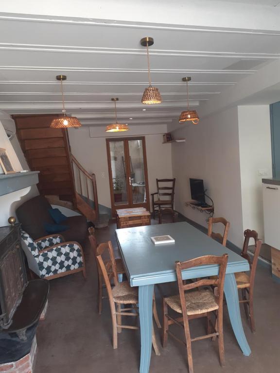 a dining room with a blue table and chairs at la maison des vendangeurs in Villesequelande