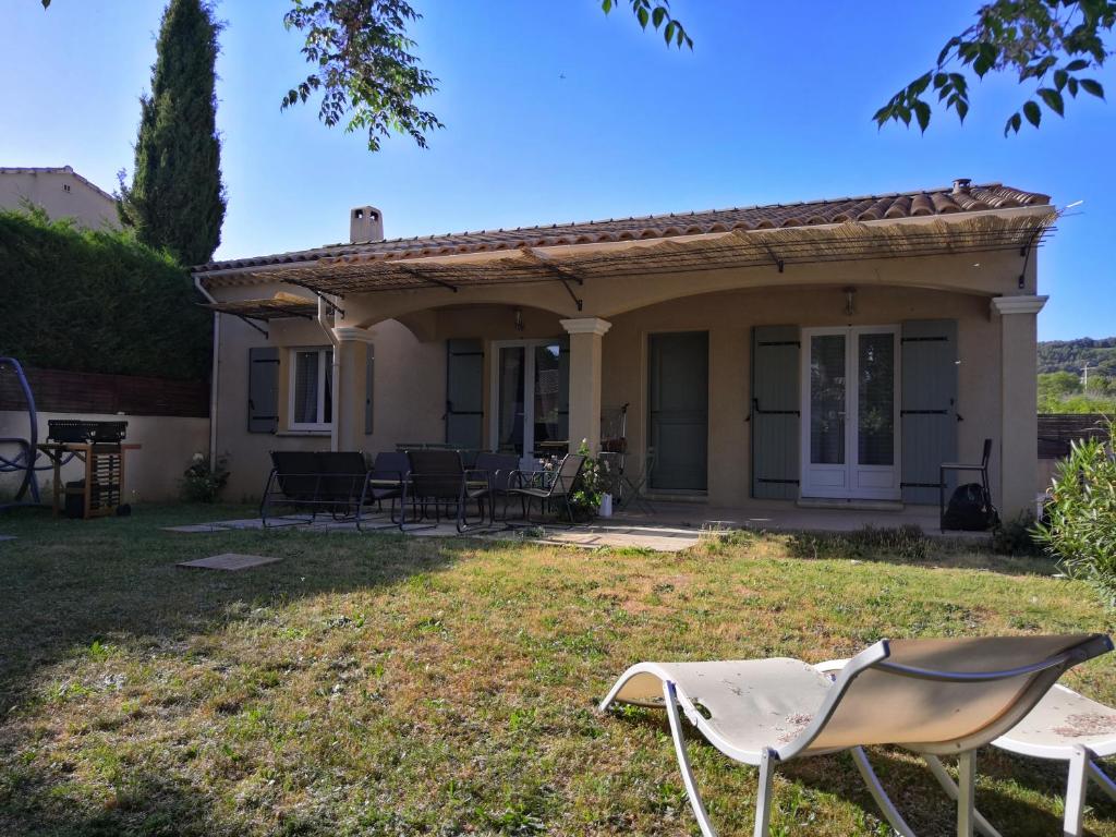 una casa con sillas en el patio en VILLA VAI avec piscine, en Vaison-la-Romaine