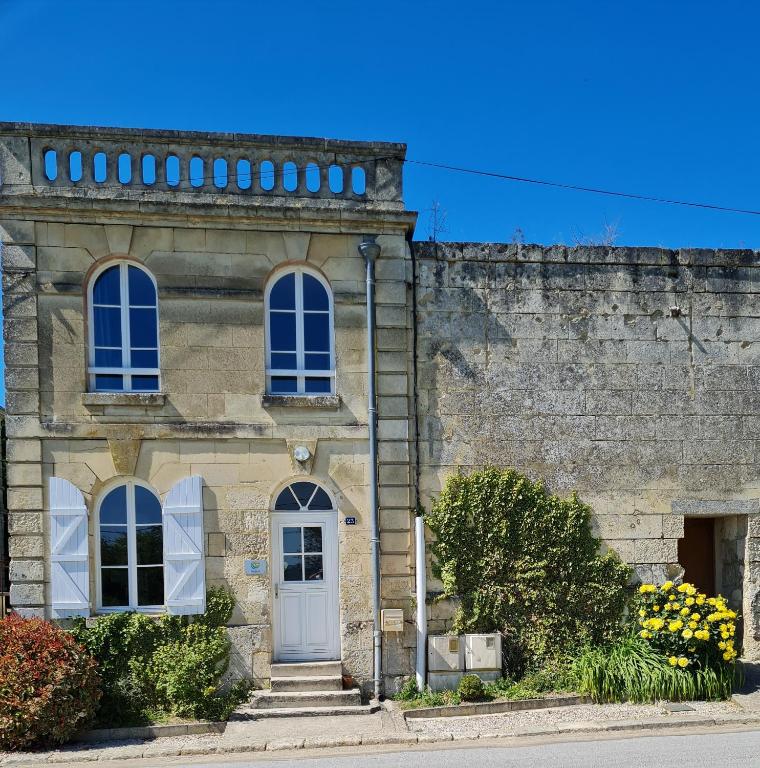 - un vieux bâtiment en pierre avec une porte blanche et des fenêtres dans l'établissement La Tour L'évêque gite 3 chambres 5 pers 5 km Soissons, à Septmonts