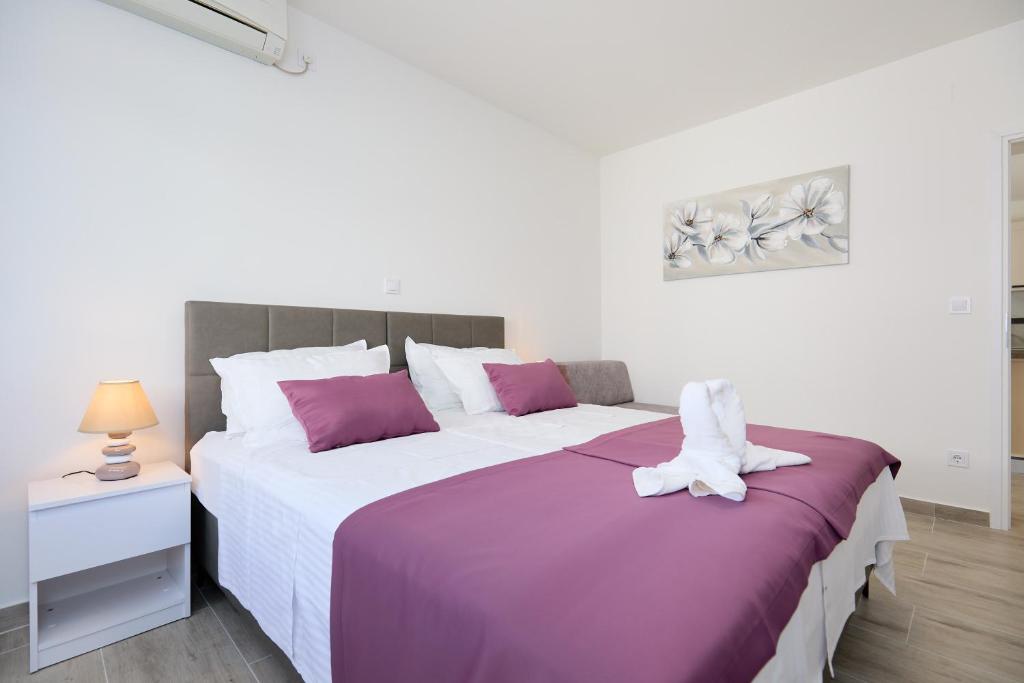 a bedroom with a large bed with purple and white sheets at Apartment Manilu in Dubrovnik