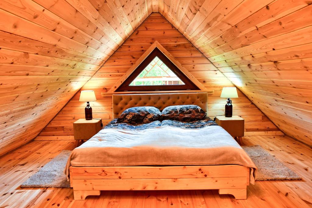 1 dormitorio con 1 cama en una cabaña de madera en Agroturystyka Pod Czernicą, en Stronie Śląskie