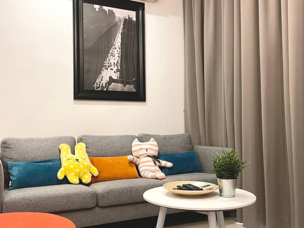 Arcoris Mont Kiara 1 to 5 pax Designer Netflix Chill Balcony في كوالالمبور: غرفة معيشة مع أريكة مع وسائد وطاولة