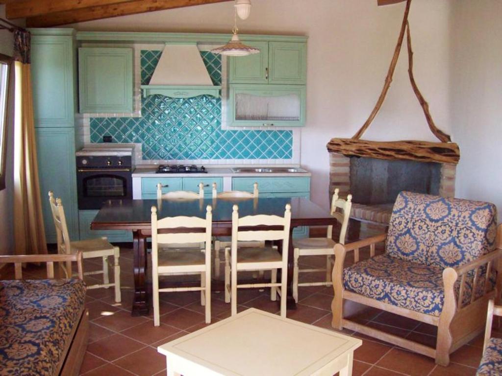 una cucina con tavolo e sedie in una stanza di 2 bedrooms appartement with sea view enclosed garden and wifi at Sassari a Sassari
