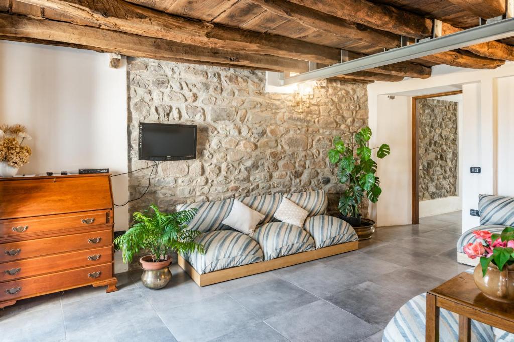 sala de estar con sofá y pared de piedra en Nearby 5Terre Authentic Apartment, en Carrodano Inferiore