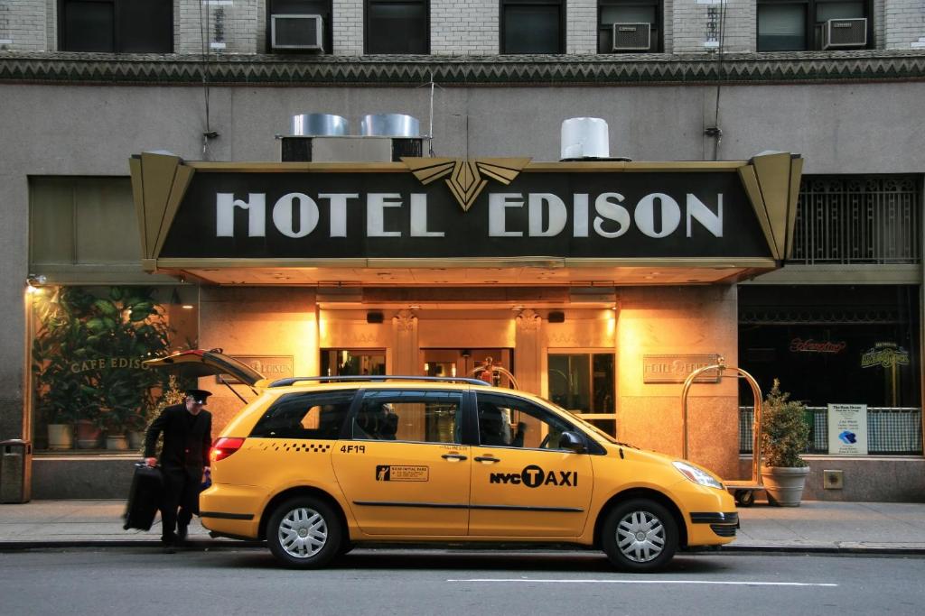 a yellow taxi cab parked in front of a hotel edison at Hotel Edison Times Square in New York