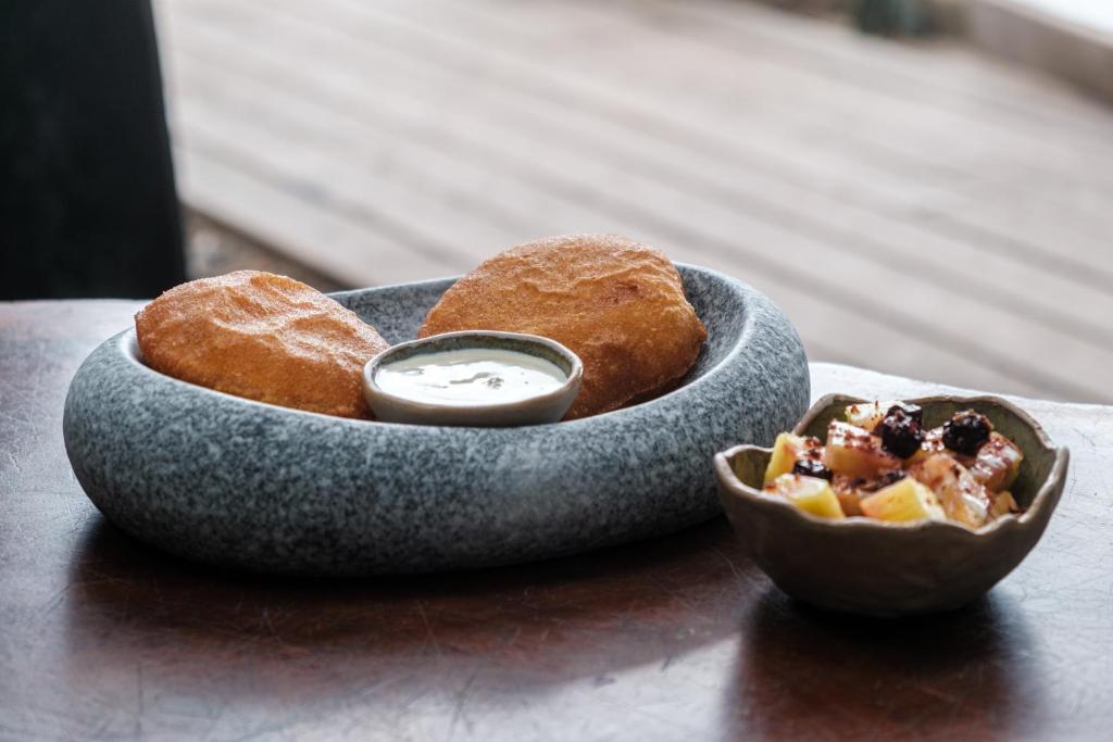a bowl of food with a pastry and a bowl of dips at Makao Beach Hotel in Palomino