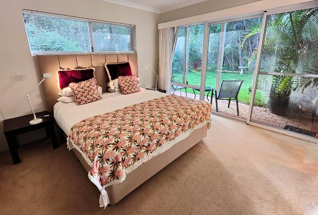 a bedroom with a bed and a large window at Margaret River Bed & Breakfast in Margaret River Town