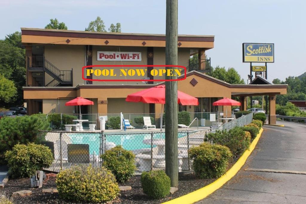una señal abierta de piscina frente a un restaurante en Scottish Inn Knoxville, en Knoxville