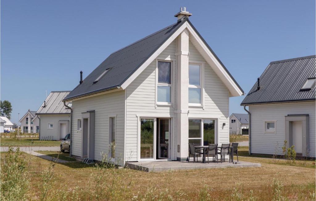 ein weißes Haus mit schwarzem Dach in der Unterkunft Awesome Home In Ostseeresort Olpenitz With Sauna in Olpenitz