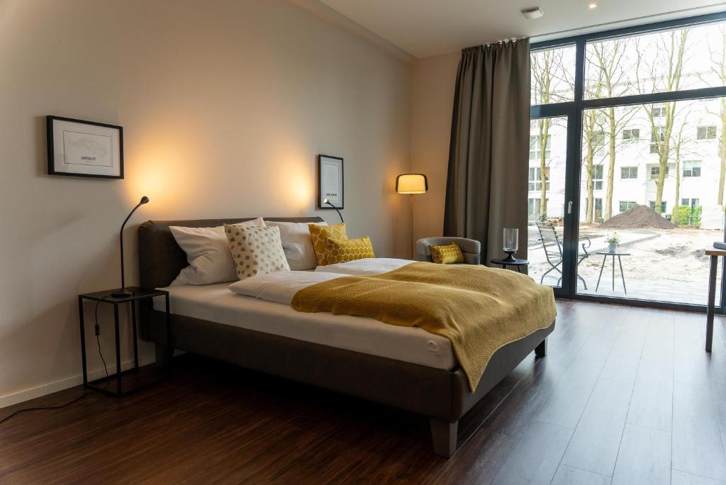 a bedroom with a bed and a large window at Arbio I Duxen Apartments Hagenbeck Zoo in Hamburg