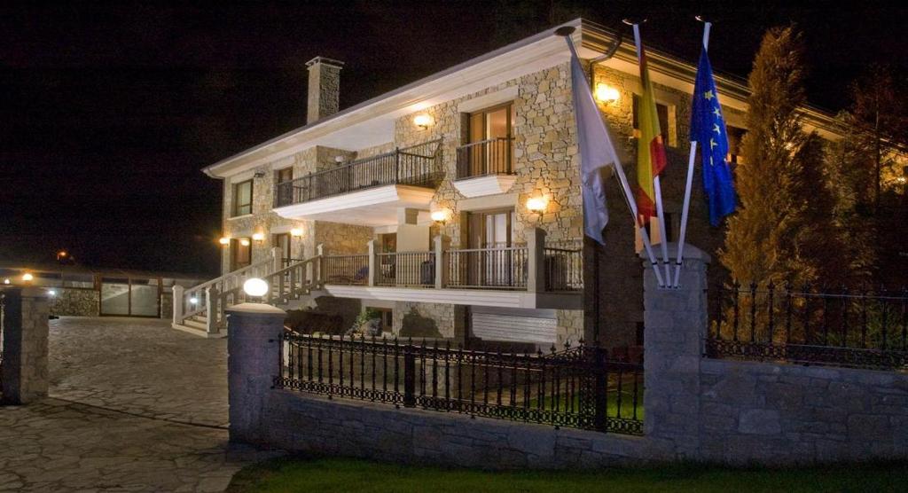 een gebouw met vlaggen er 's nachts voor bij Casa Buda Conors in Foz