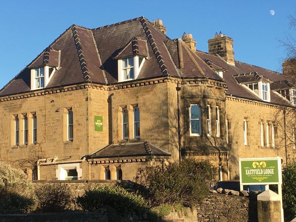 a large brick house with a sign in front of it at Eastfield Lodge in Leyburn