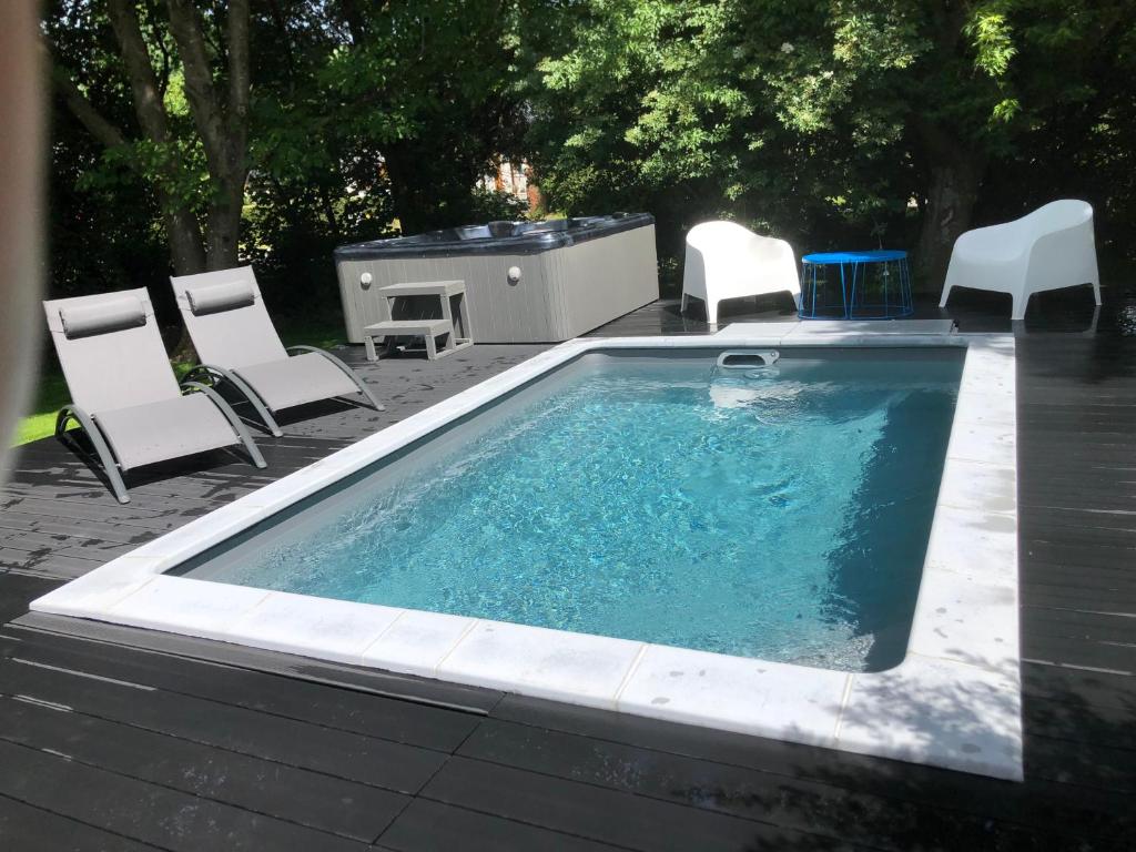 a pool with chairs and a table and a grill at PAUSE NATURE SORBAIS Gite de groupe avec Piscine, Spas, Sauna et Hammam Shower avec 8 chambres et 8 salles de bain, grande cuisine et grande salle de vie in Sorbais