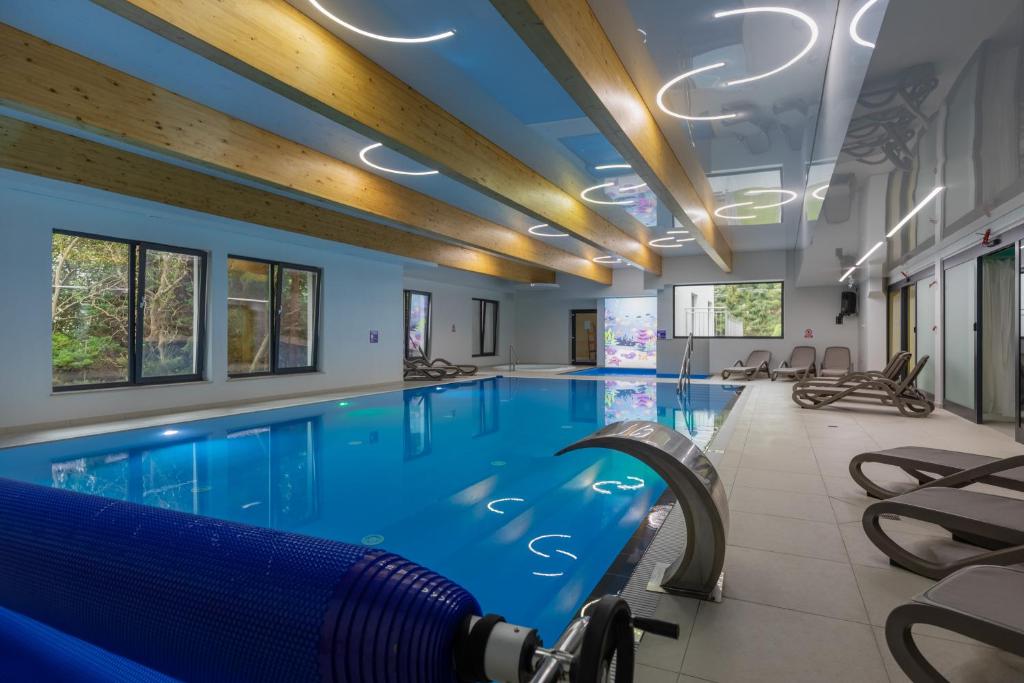 una gran piscina de agua azul en Seaside Apartamenty Dominikana Sianożęty Basen&Jakuzzi&Parking, en Sianożęty