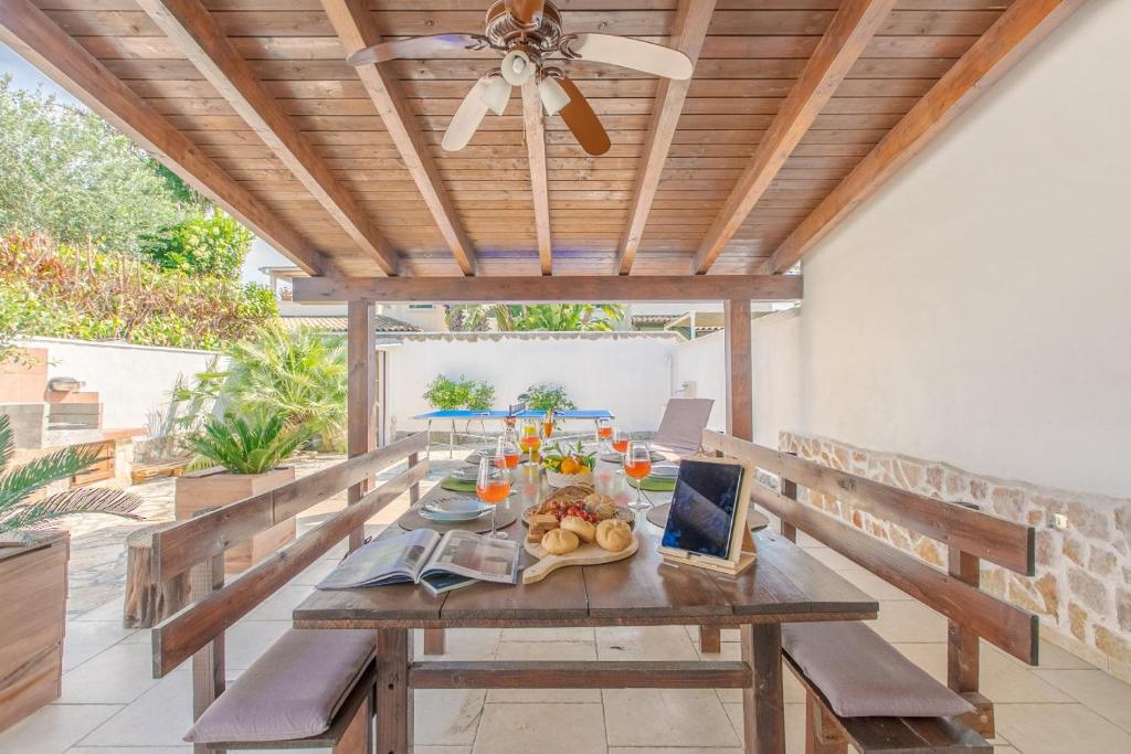 a wooden table with fruit on it on a patio at Villa Agave al mare in Specchiolla