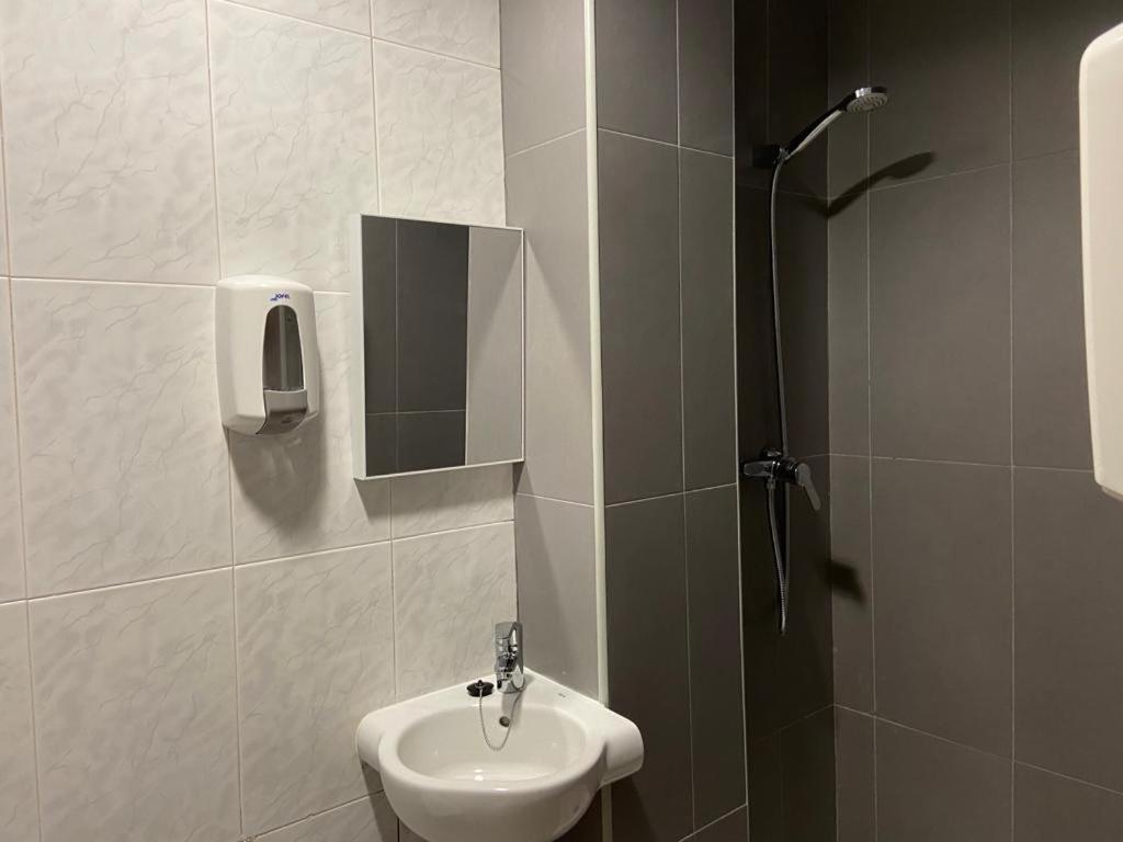 y baño con lavabo y ducha. en Pensión Santa Rita en Calatayud