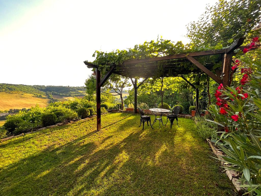 a garden with two chairs under a pergola at Le Songe d'Atys in Cordes-sur-Ciel