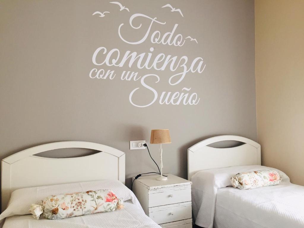 a bedroom with two beds and a sign that reads tala cambria can at Vivienda Verano in Noja