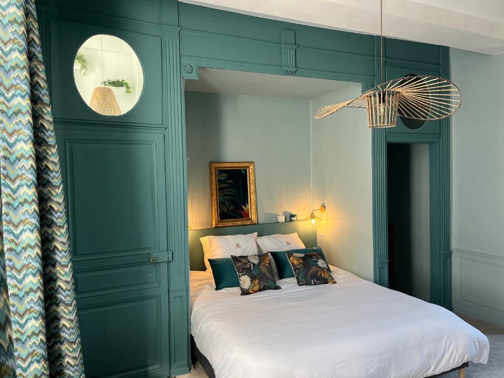 - une chambre dotée d'un lit avec un mur vert dans l'établissement Aux Remparts de Montreuil, à Montreuil-sur-Mer
