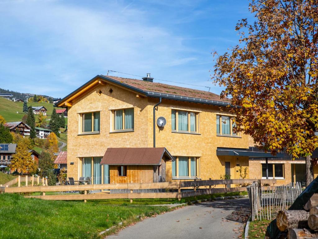 a large yellow brick house with a driveway at Chalet Alpenluft in Hirschegg
