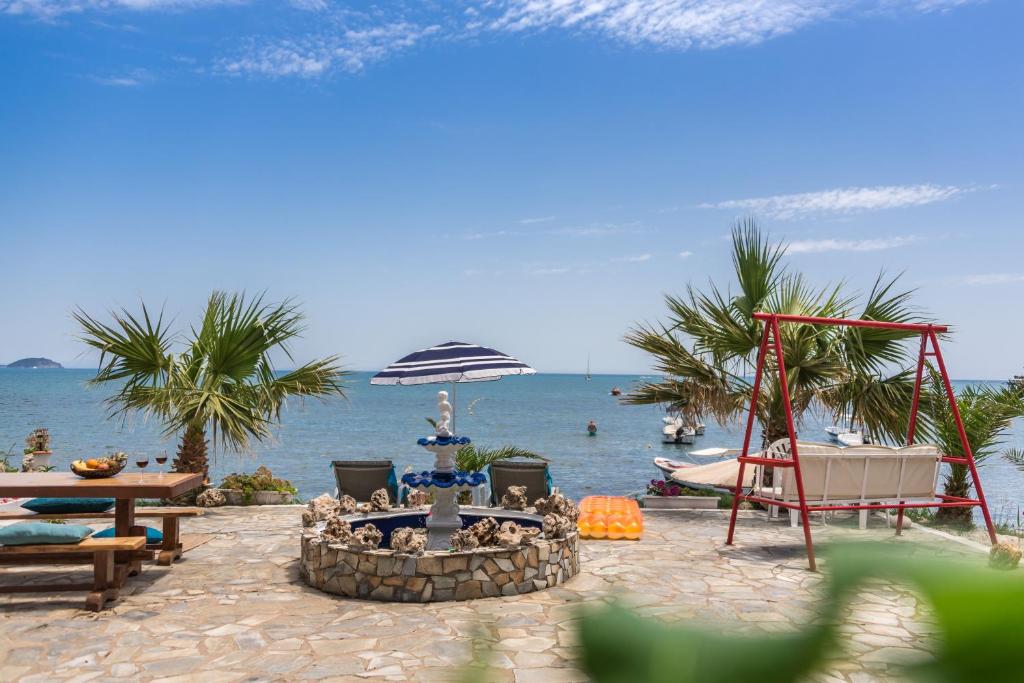 a fire pit on the beach next to the ocean at Villa Milano in Laganas