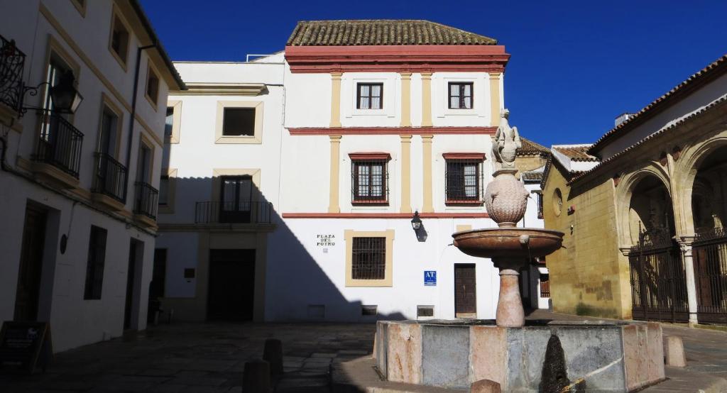 a building with a fountain in the middle of a street at Apartamentos Plaza in Córdoba
