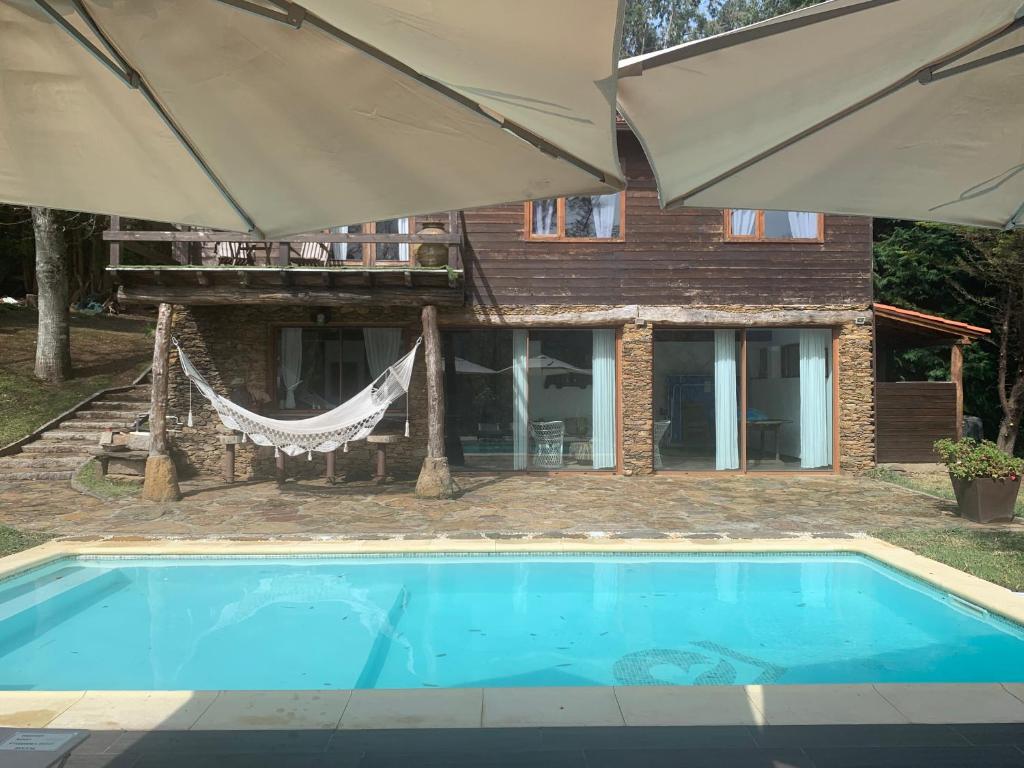 ein Pool mit zwei Sonnenschirmen neben einem Haus in der Unterkunft Refugio da Raposa in Caminha