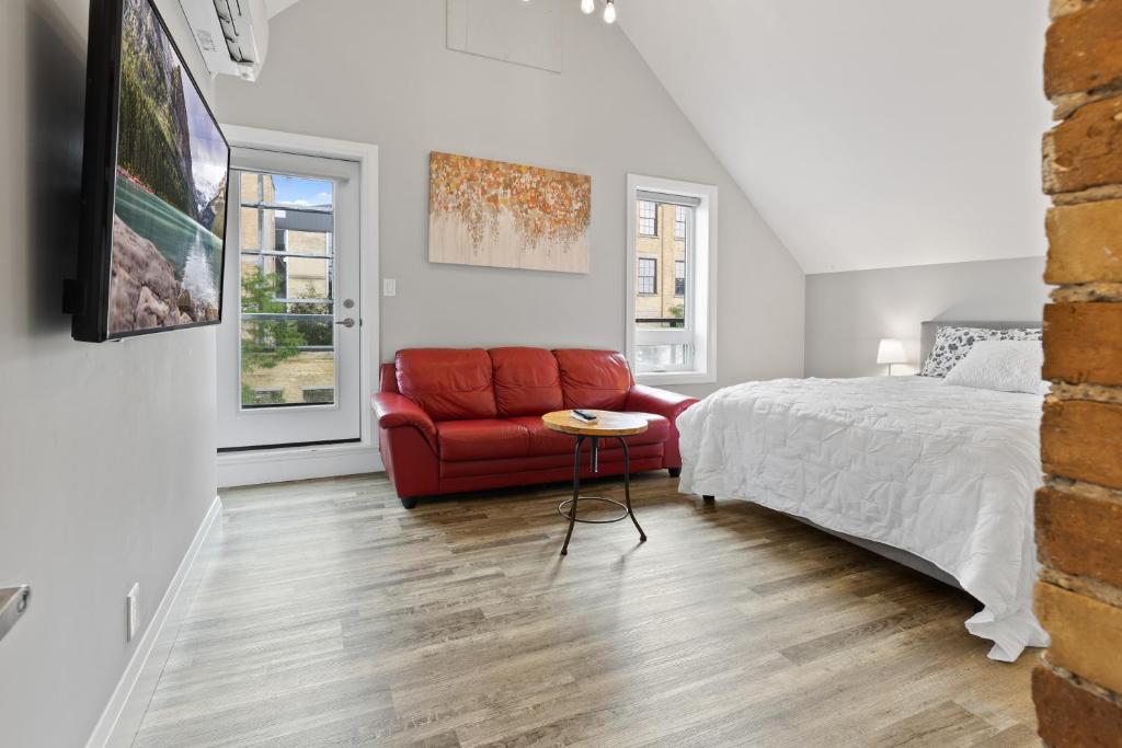 1 dormitorio con 1 cama y 1 sofá rojo en ENTIRE 3-UNITS TOP-FLOOR ACROSS FROM GOOGLE, en Kitchener