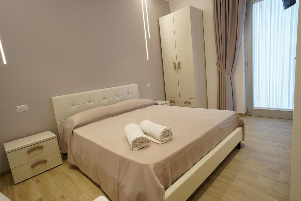 1 dormitorio con 1 cama con 2 toallas en Punta Pagliaia rooms en Margherita di Savoia