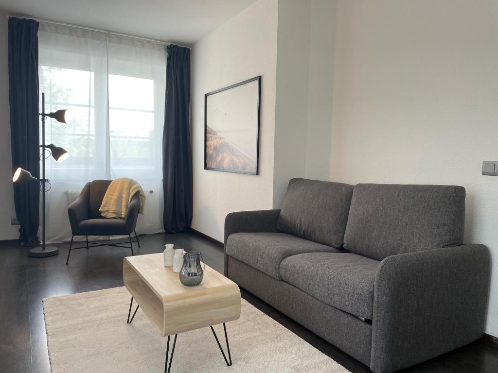 ein Wohnzimmer mit einem Sofa und einem Tisch in der Unterkunft Airport Apartments for 4 - Kitchen - Parking with eCharging in Hamburg