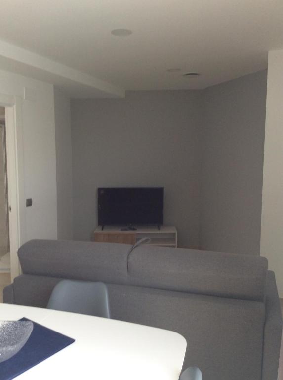 A television and/or entertainment centre at Apartamentos Hostería de Boo